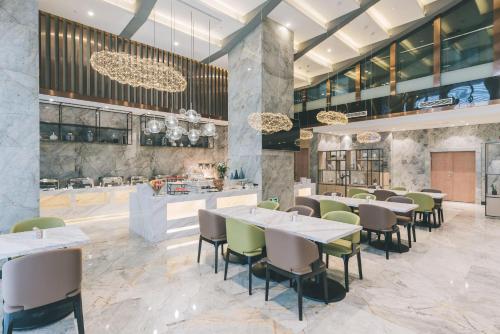 a restaurant with tables and chairs and a bar at Atour Hotel Kunshan Yongda Business Plaza in Kunshan