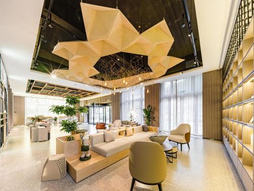 a lobby of a hotel with a large ceiling at Atour Hotel Jiaxing Haiyan Haifeng Road in Haiyan