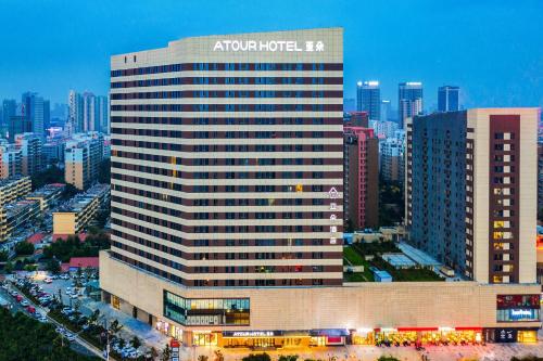 a large building with the apazonicak sign on it in a city at Atour Hotel Jining Lingxiu City Plaza in Jining