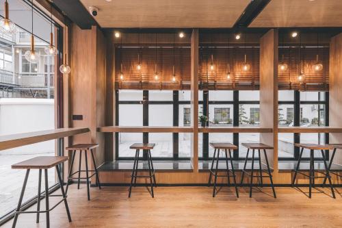 a bar with stools in front of a window at Atour Light Nanjing Xinjiekou NetEase CloudMusic in Nanjing