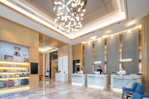 a lobby with two people sitting at a counter at Atour Hotel Lanzhou Xigu in Lanzhou