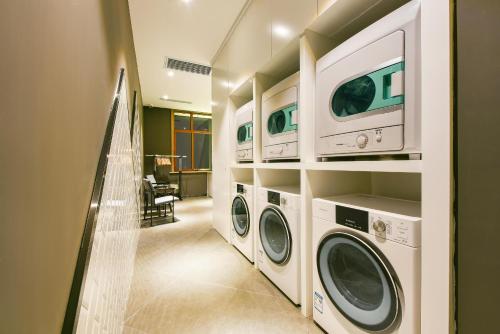uma lavandaria com duas máquinas de lavar e secar roupa em Atour Hotel Baotou Xitu em Baotou