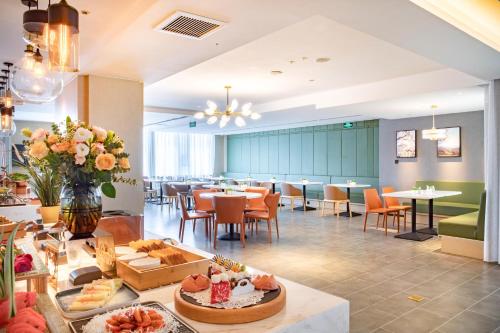 a hotel lobby with tables and chairs and a cafeteria at Atour Hotel Jining Lingxiu City Plaza in Jining