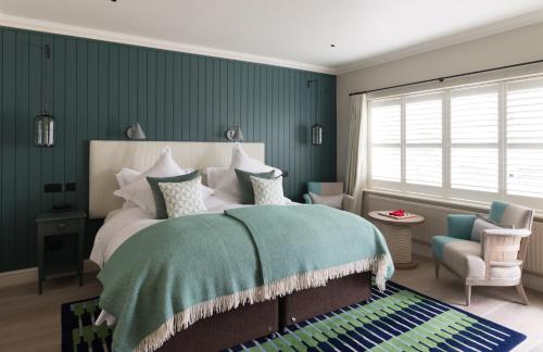 
a bedroom with a large bed and a large window at The Swan Hotel in Southwold
