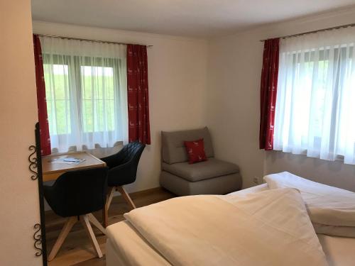 1 Schlafzimmer mit 2 Betten, einem Schreibtisch und einem Stuhl in der Unterkunft Gästehaus Hosp in Reutte