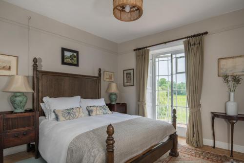 a bedroom with a large bed and a window at Shrewton House - Stunning 4 double ensuite bedrooms in Shrewton