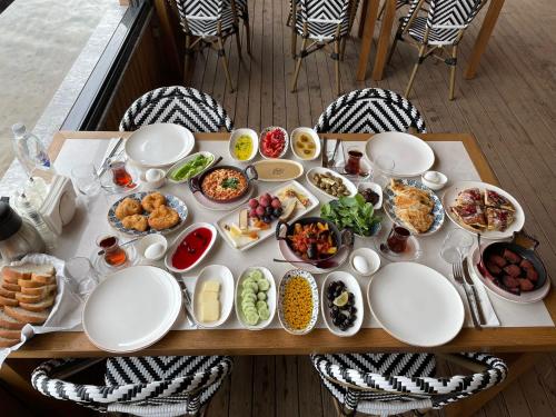 un tavolo pieno di piatti e ciotole di cibo di Pino Mar Luxury Bungalows a Erdek
