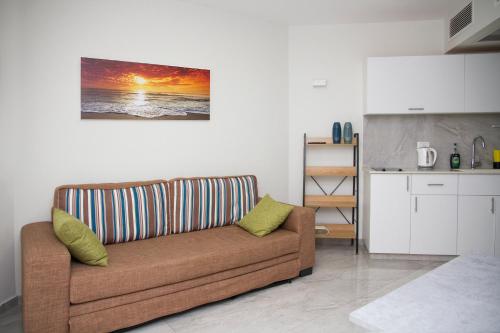 a living room with a couch in a kitchen at Apartments4you Leonardo 11 in Bat Yam