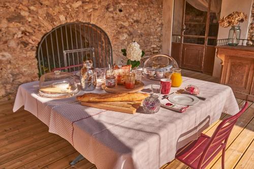 - une table avec de la nourriture et du pain en haut dans l'établissement LES OLIVANIES, à Monthelon