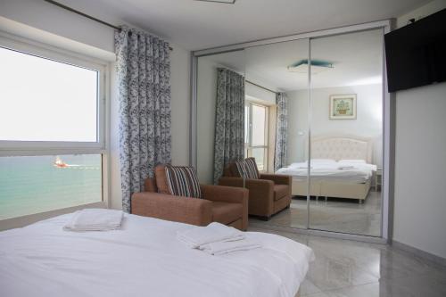 Una habitación de hotel con una cama y un dormitorio. en Apartments4you Leonardo 11, en Bat Yam