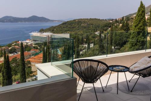 uma varanda com 2 cadeiras e vista para a água em Luxury Villa Helios 5* em Dubrovnik