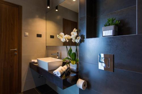 un bagno con un lavandino e un vaso di fiori di Luxury Villa Helios 5* a Dubrovnik