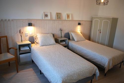 una habitación de hotel con 2 camas y una silla en Casa da Annelies. Accessible holiday home, en Nadadouro
