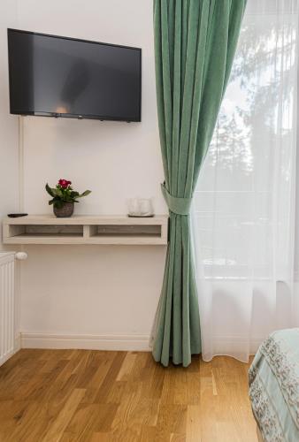 a green curtain in a room with a window at Pensiunea Hilltop in Predeal