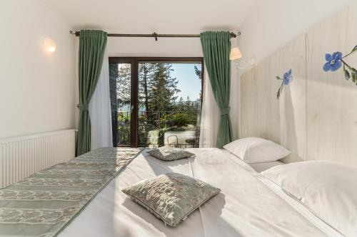 a bedroom with a large bed and a window at Pensiunea Hilltop in Predeal