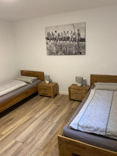 Cette chambre comprend 2 lits et une photo murale. dans l'établissement Ferienwohnung Familie Heite, à Olpe