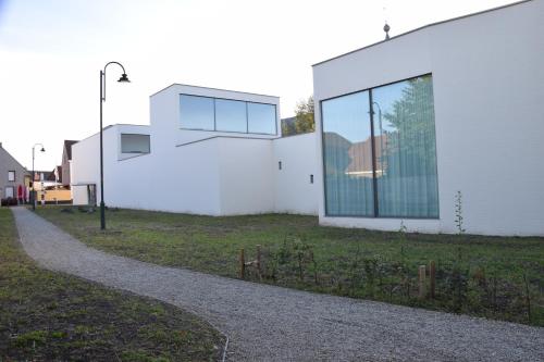 a white building with glass windows on the side of it at CaCeLe Raveelzicht in Zulte