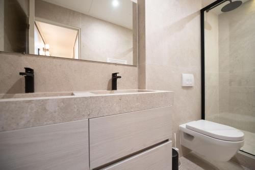 une salle de bain avec un lavabo, des toilettes et un miroir dans l'établissement MBM - Echiquier, à Paris