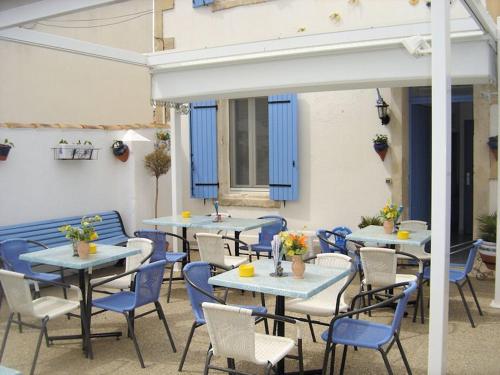 a group of tables and chairs with flowers on them at Le Cocardier in Saintes-Maries-de-la-Mer