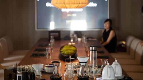 a woman standing behind a long table with glasses at Intercontinental Shenzhen Dameisha Resort by IHG in Shenzhen