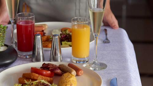 a table with a plate of food and two glasses of juice at Intercontinental Shenzhen Dameisha Resort by IHG in Shenzhen