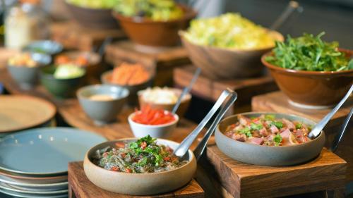 a table topped with bowls of food with spoons at Intercontinental Shenzhen Dameisha Resort by IHG in Shenzhen