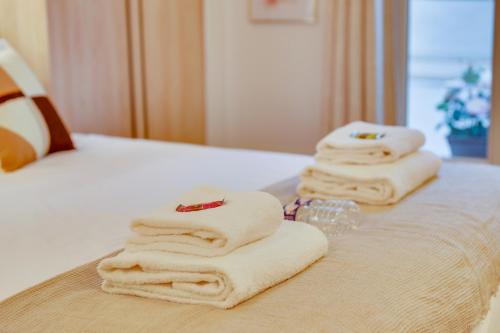 - un ensemble de serviettes empilées sur un lit dans l'établissement Central Historical Studio by Architect - Louvre, à Paris