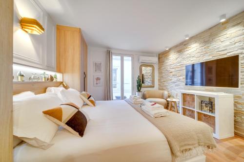 une chambre avec un grand lit blanc et une télévision dans l'établissement Central Historical Studio by Architect - Louvre, à Paris
