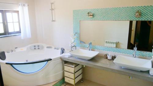 La salle de bains est pourvue de 2 lavabos et d'un grand miroir. dans l'établissement Casa da Joana, Quinta Carmo - Alcobaça/Nazaré, à Alcobaça