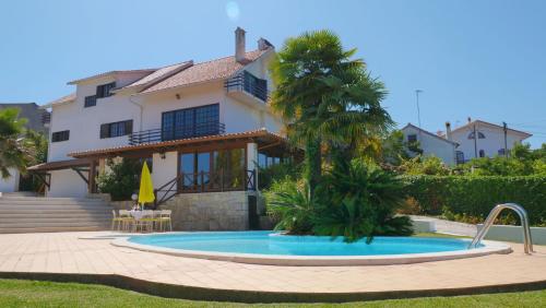 une villa avec une piscine en face d'une maison dans l'établissement Casa da Joana, Quinta Carmo - Alcobaça/Nazaré, à Alcobaça