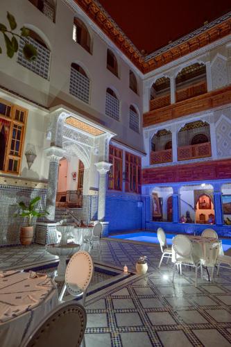 a room with chairs and tables in a building at Riad Sayeda Al Hora in Fès