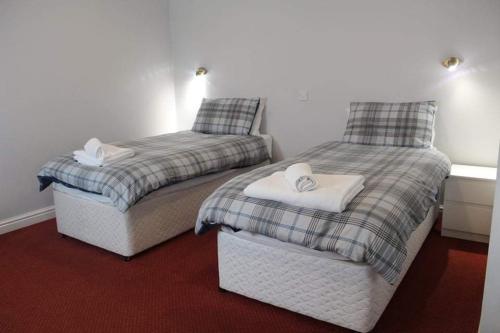 two beds sitting next to each other in a room at The Sportsman Chalets in Kent