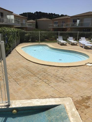 - une petite piscine dans une cour avec 2 chaises longues dans l'établissement T2 Les jardins Gruissan, à Gruissan