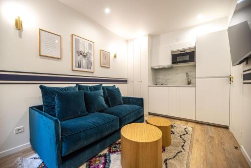 un salon avec un canapé bleu et une cuisine dans l'établissement MBM - CHARONNE, à Paris
