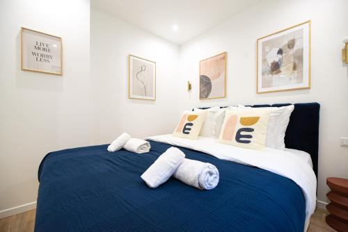 - une chambre avec un lit bleu et blanc et des serviettes dans l'établissement MBM - CHARONNE, à Paris