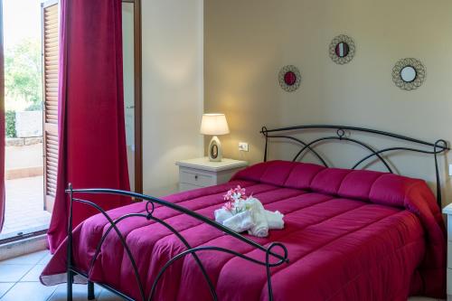 un letto con una coperta rosa e fiori sopra di Il Borgo Appartamenti a Olbia