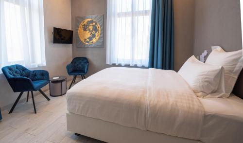 a bedroom with a large white bed and two blue chairs at Liebknecht 13 in Bernburg