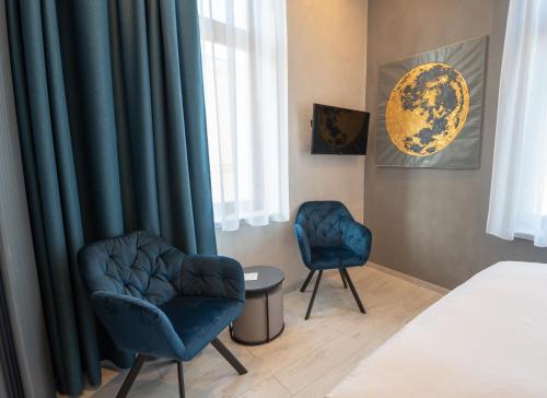 a bedroom with two blue chairs and a bed at Liebknecht 13 in Bernburg