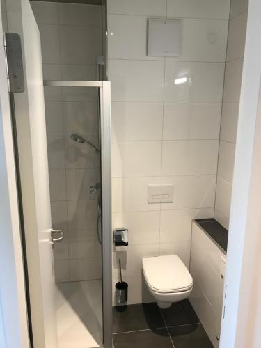 La petite salle de bains est pourvue d'une douche et de toilettes. dans l'établissement SITE.INN Hamburg, à Hambourg