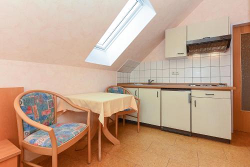 a kitchen with a table and chairs in a room at Hotel-Pension Altes Siel in Bensersiel