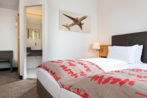 una camera d'albergo con un letto con un disegno di un aereo sul muro di Holiday Inn Frankfurt Airport - Neu-Isenburg, an IHG Hotel a Neu Isenburg