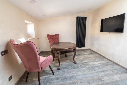 a room with a table and two chairs and a tv at Liebknecht 13 in Bernburg