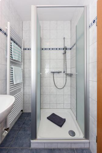 a bathroom with a shower and a sink at Hotel-Pension Altes Siel in Bensersiel