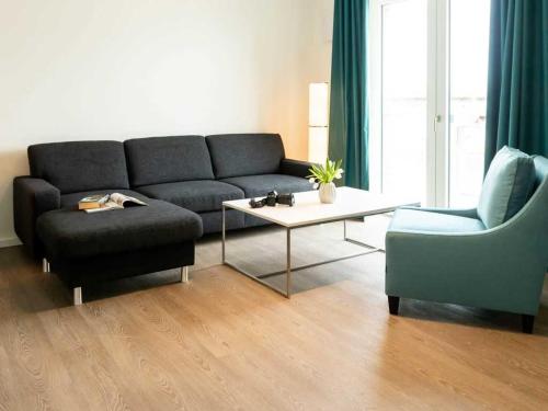 een woonkamer met een bank en een stoel bij Hafenspitze App 04 in Wismar