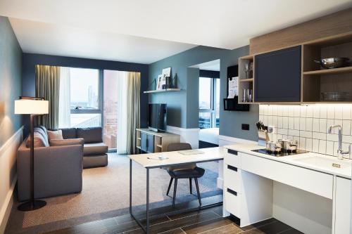 a kitchen and living room with a table and a couch at Hyatt House Manchester - Aparthotel in Manchester