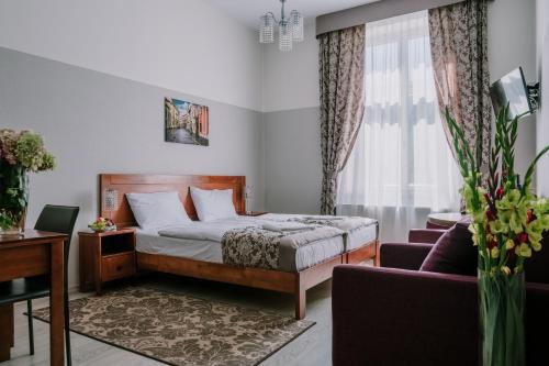 a bedroom with a bed and a desk and a couch at DReAM Garden Palace in Kraków