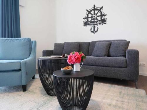 uma sala de estar com um sofá e uma mesa com flores em Hafenspitze App 05 em Wismar