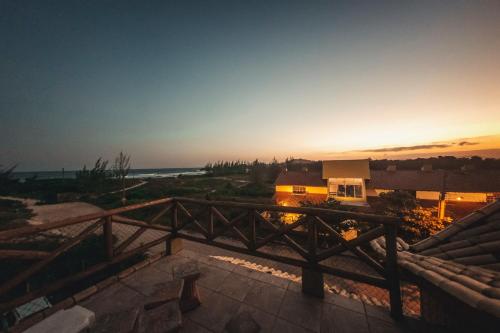 a view of a sunset from the balcony of a house at Pousada Pé na Areia in Garopaba