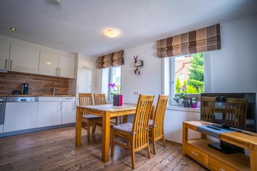 a kitchen with a wooden table and chairs in a kitchen at MINAROSO appartements am badeparadies in Titisee-Neustadt
