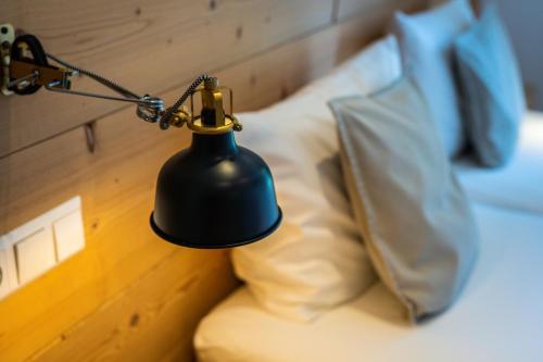 a lamp sitting on top of a bed with a pillow at MINAROSO appartements am badeparadies in Titisee-Neustadt
